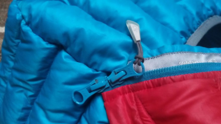 Dvoucestný hlavní zip YKK bundy Sir Joseph Apris Hooded II s dlouhým táhlem jezdce.