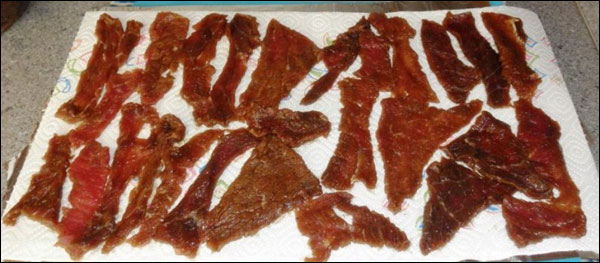 Osušené maso jsem začal napichovat na špejle tak, aby se jednotlivé proužky navzájem nedotýkaly.