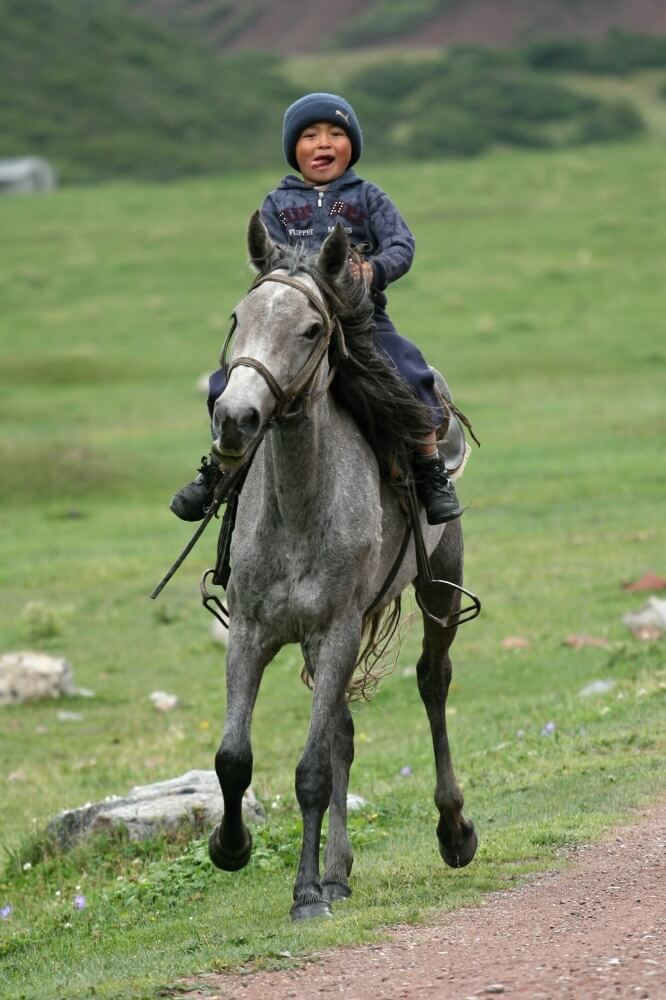 Se zájmem pozorujeme malé děti, které sotva umí chodit a už sedí na hřbetech koní, bez sedel se prohánějí rychlostí blesku, pokřikují na nás a mávají.