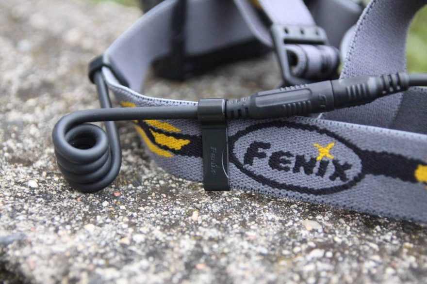 Kabel na pásku drží plastovými klipy. Je třeba je přetočit vzhůru nohama, jinak škrábou do uší