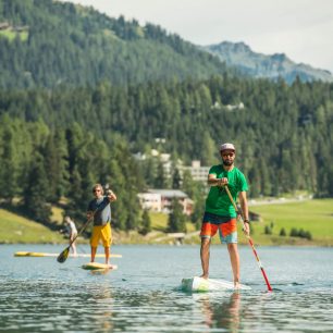 Díky kartě Davos Klosters Premium Card je plno aktivit v regionu za výhodné ceny, např. paddleboard na Davosersee. Destination Davos Klosters / Christian Egelmair