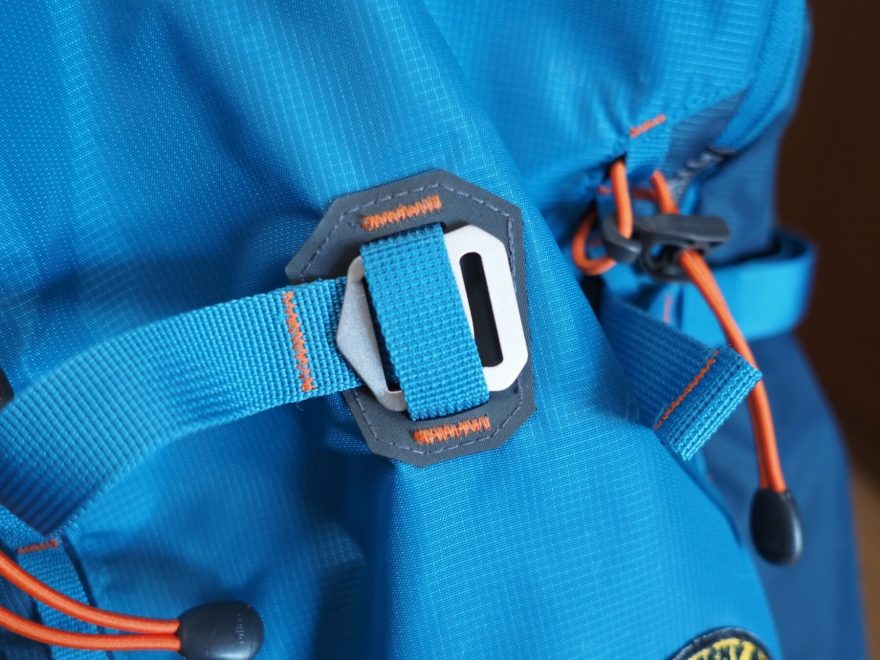 Detail protahování kovového háčku středním poutkem pro umožnění nošení prkna