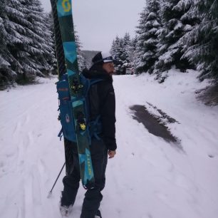 Připnutí lyží na batoh do (H)Áčka je rychlejší než diagonálně, ale občas se stane, že se nakopnete o hranu lyží