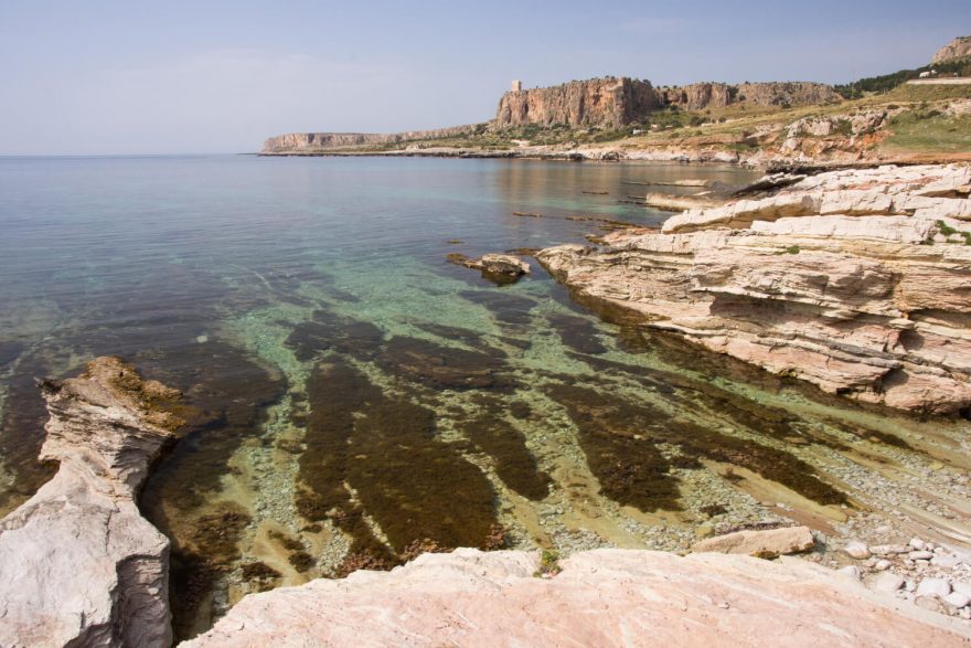 Čisté more a skály, které jsou domovem krabů poustevníčků, sasanek i mořských ježků, Sicílie