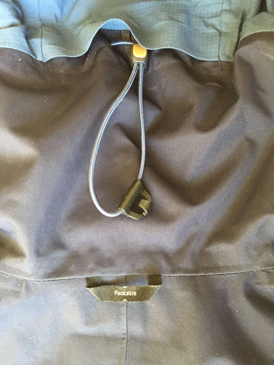 Detail samosvorného stahování kapuce s poutkem na zavěšení