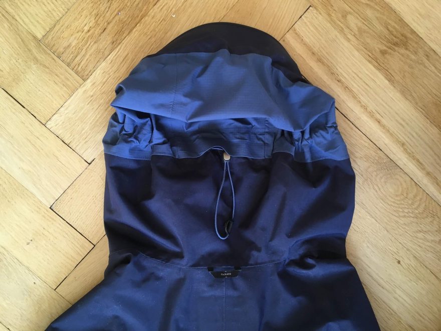 Stahování kapuce na temeni hlavy a poutko na zavešení bundy