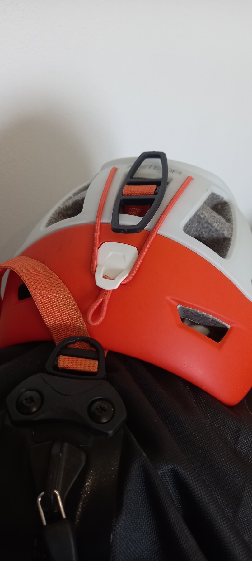 Na batoh Ortlieb Atrack BP 25 lze jednoduše a rychle připevnit přilbu. Slouží k tomu plastový díl na středovém stahovacím popruhu.