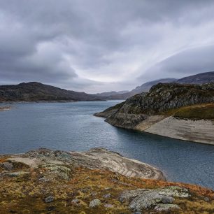 Nečekaně nízká hladina jezera Sandvatnet. Trek v jižním Norsku.