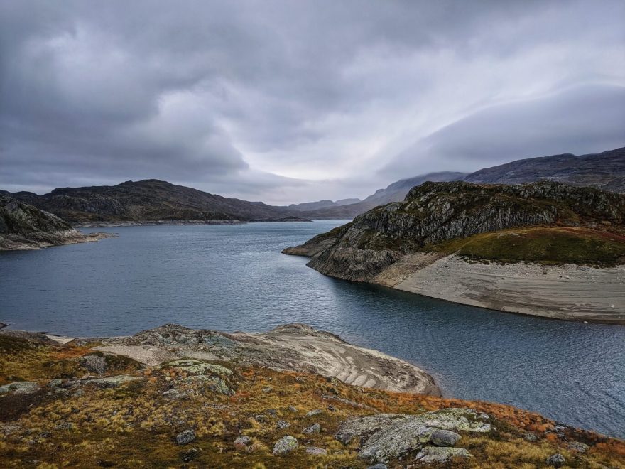 Nečekaně nízká hladina jezera Sandvatnet. Trek v jižním Norsku.
