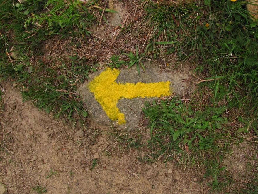 Typické žluté šipky na Svatojakubské cestě, Camino de Santiago, Španělsko.