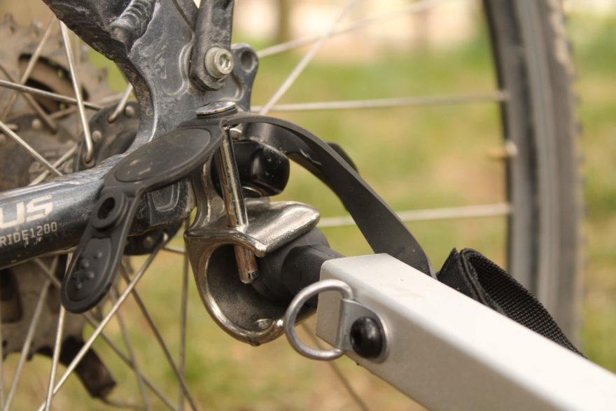 Detail připevnění tažné tyče pro cykloúpravu vozíku Thule Courier na osičku zadního kola