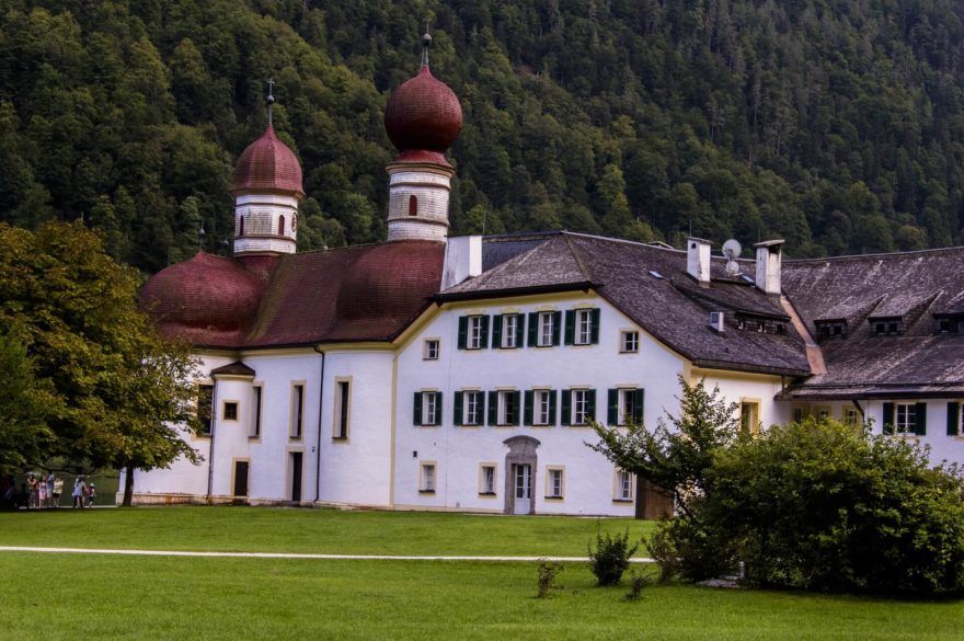 Kostelík sv. Bartoloměje stojí pod strmými srázy hor na břehu jezera Königssee, Berchtesgaden.
