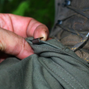 Dole je na nohavice kalhot TOMMY našitý, podobně jako tiomu je třeba u sněžných návleků. malý háček, který se zachytí na šněrovadlo bot a drží