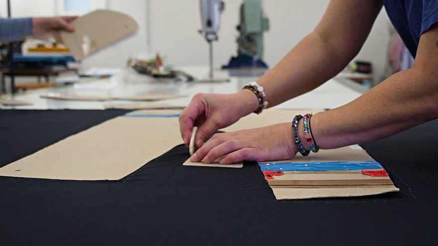 Nátah – prvotní fáze výroby oblečení Sensor. Po obkreslení šablon na látku se natáhne několik vrstev látky, ze které se pak vyřezávají jednotlivé díly oblečení.