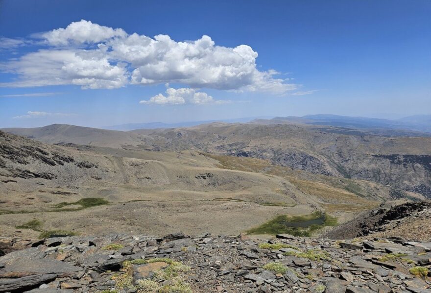 Hned pod vrcholem bývala dříve chata, za ní je vidět zelená oblast kolem Laguna Hondera (2900 m)