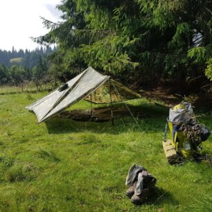 Přístřešek z plachty podepřený holemi, případně tarp, šetří váhu i místo v batohu.