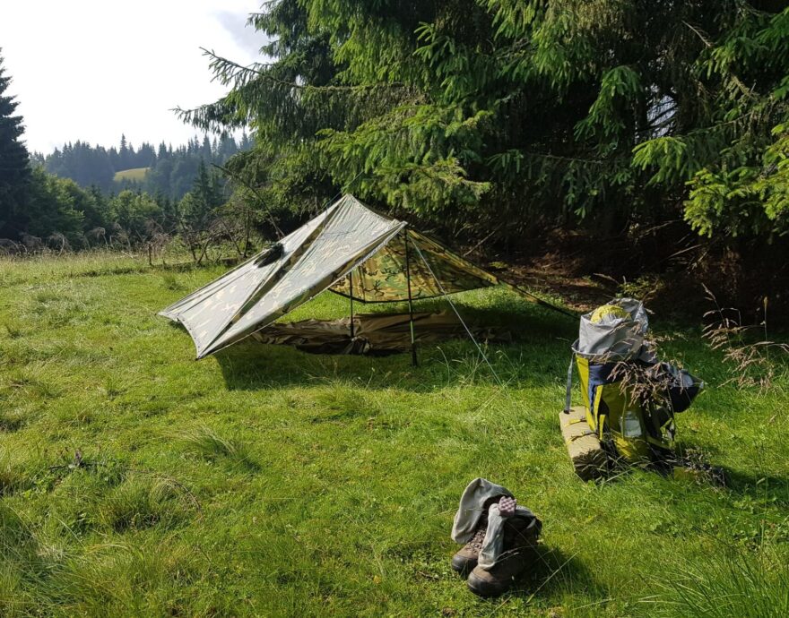 Přístřešek z plachty podepřený holemi, případně tarp, šetří váhu i místo v batohu.