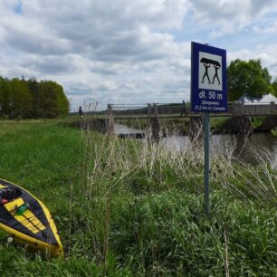 Na cedulích označujících přenášení je vždy uvedena i délka přenášky. Fotografie je z řeky Liswarta.