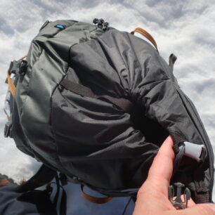 Stahovací systém hlavního prostoru batohu Thule Stir Alpine. Po utažení se dá zajistit plastovou přezkou a dotáhnout. Toto stahování lze využít i pro upevnění lana