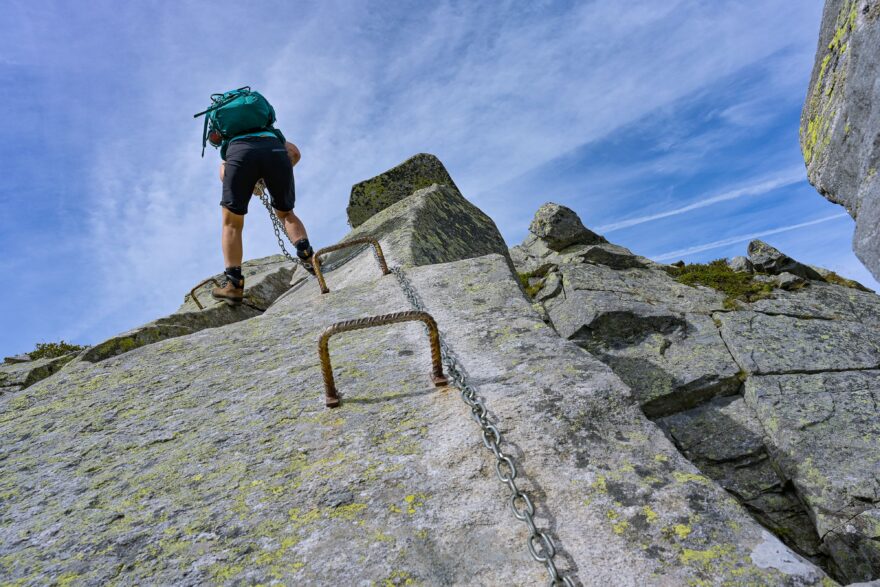 Druhý den překonáváme vzdušnou hřebenovou pasáž obtížnosti T5– s řetězy a železnými kramlemi a přitom hledíme do kilometrové hlubiny.