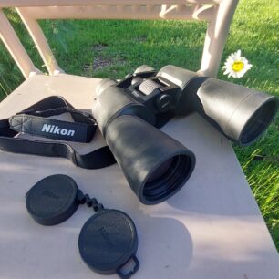 Dalekohled NIKON ACTION ZOOM je opatřen popruhem a ochranou skel