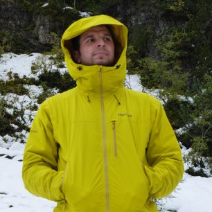 Vysoký límec a velká kapuce jsou dimenzované na použití lyžařské helmy