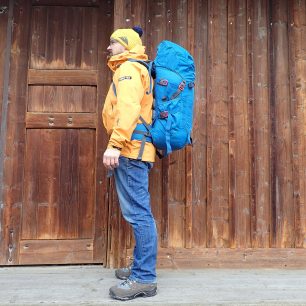 Boční pohled na nasazený batoh. Výška postavy 174 cm.
