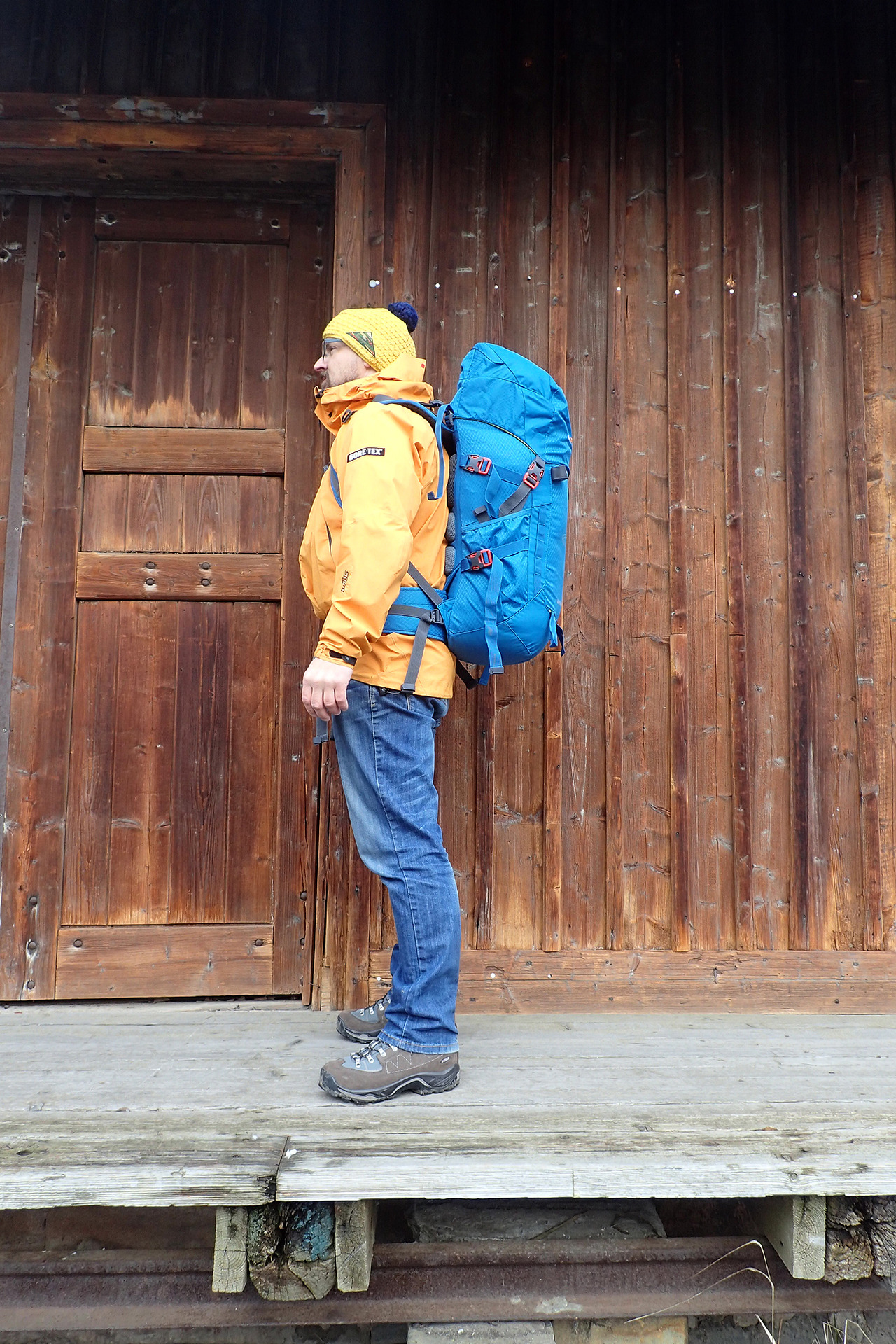 Boční pohled na nasazený batoh. Výška postavy 174 cm.
