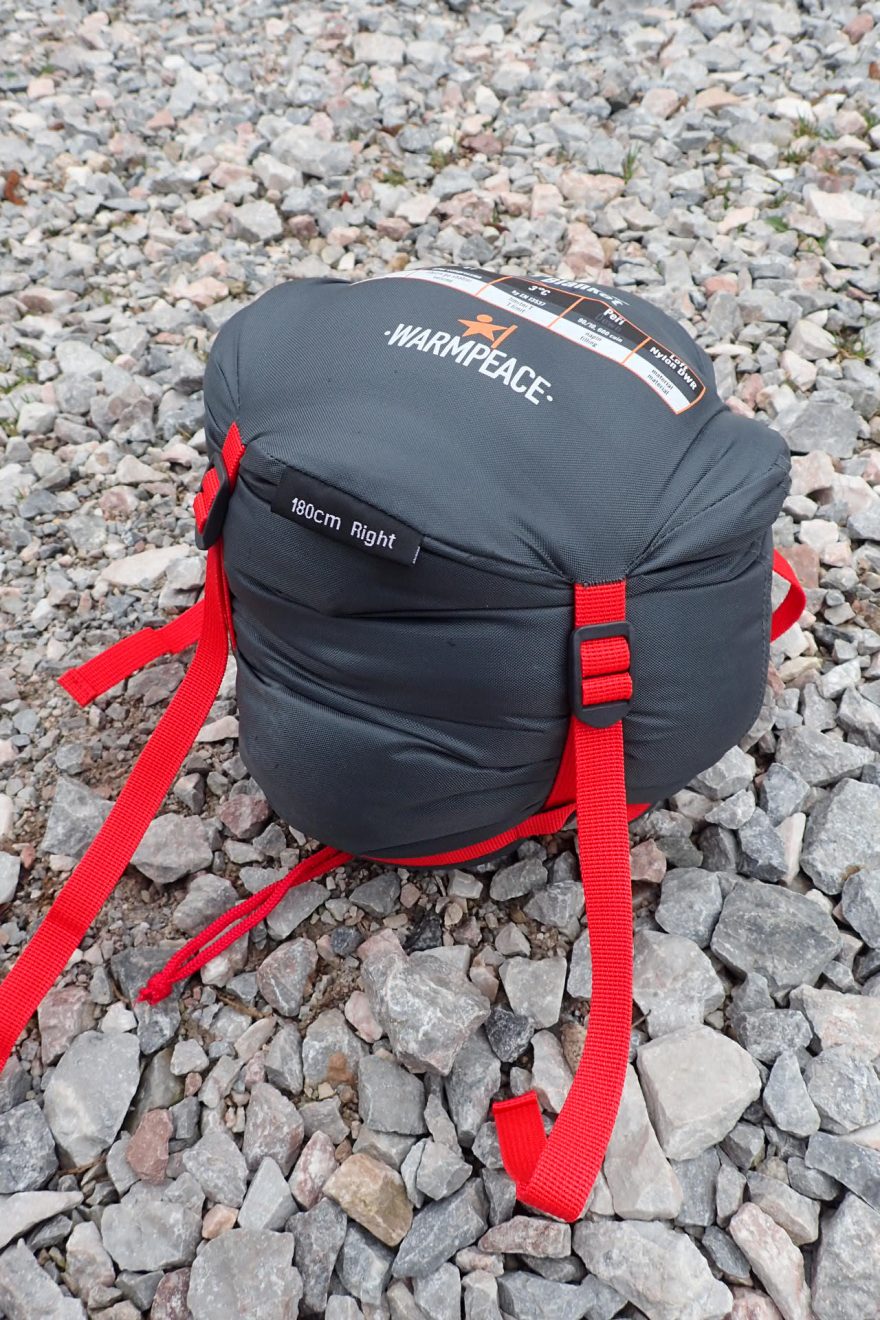 Spacák v kompresním obalu po zatažení. Šířka cca 15 cm.