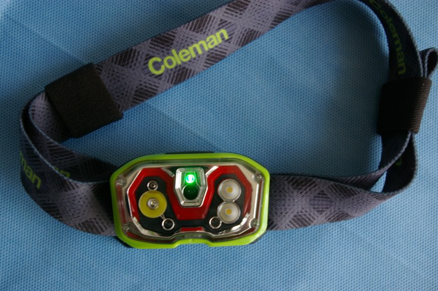 Čelovka Coleman CXS300 zapnutá se zelenou signalizací.