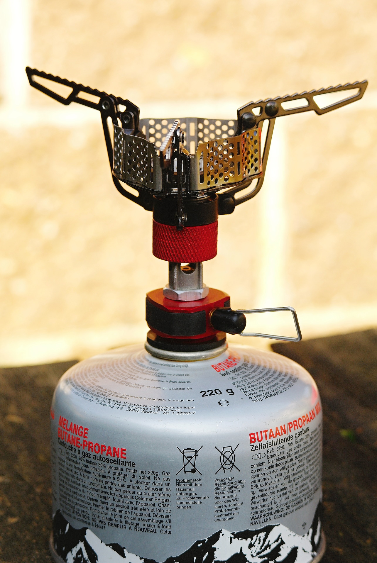 Vařič Coleman FYRESTORM s rozloženými podpěrami.