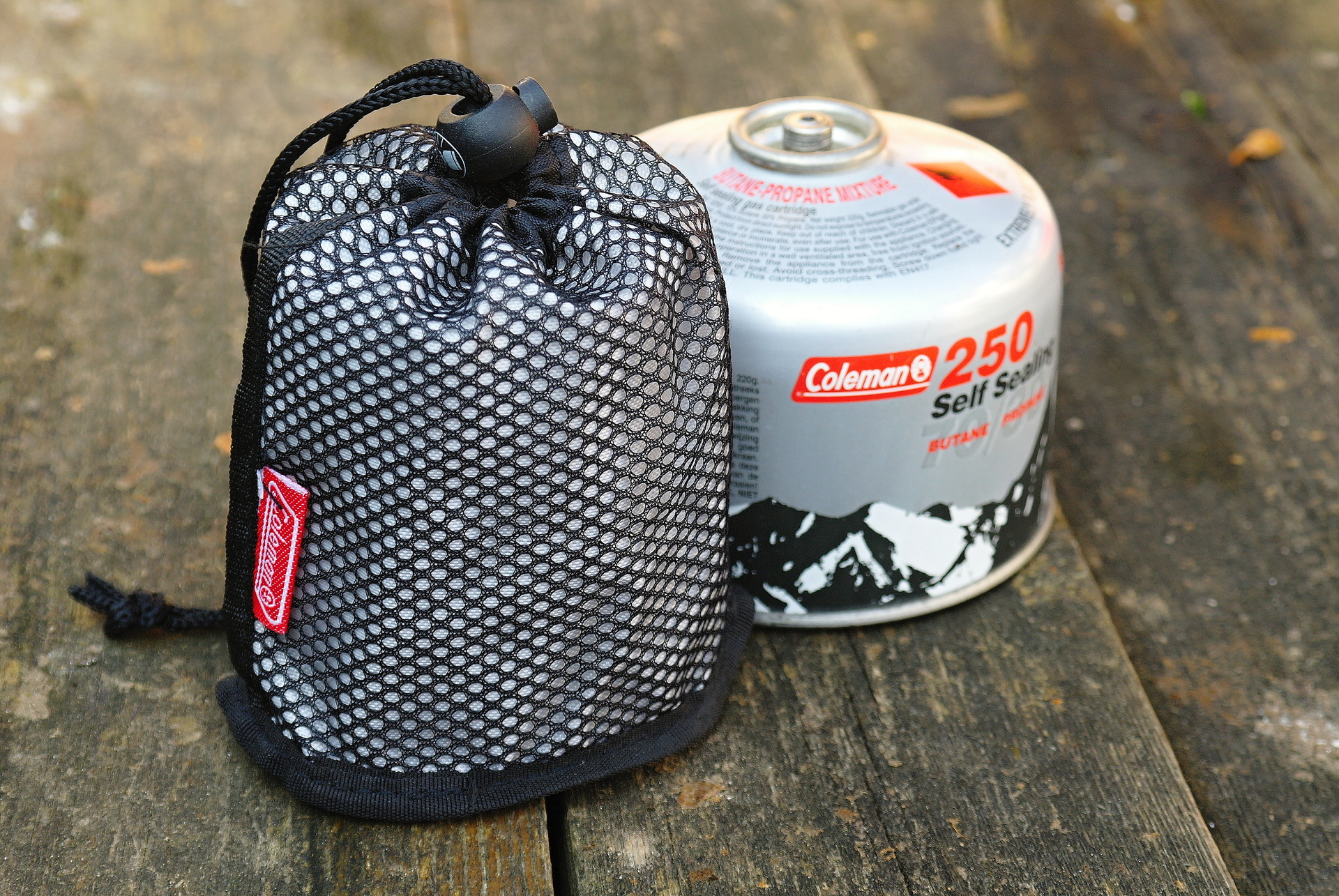 Vařič Coleman v transportním obalu a kartuše.JPG