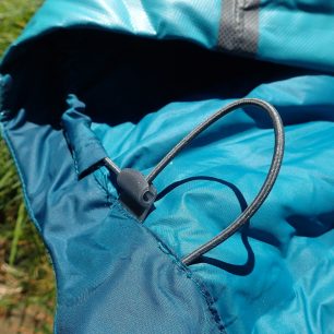 Po zatažení kapuce stačí pružnou tkanici jenom zaseknout do V výřezu a drží.