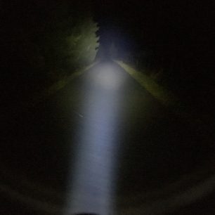 Úzký kužel světla na silnici.