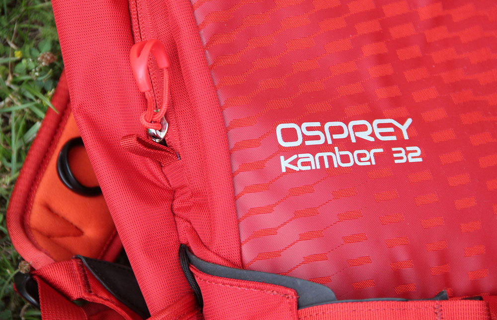 Červené zakončení zipu kryjícího komoru na lavinové vybavení