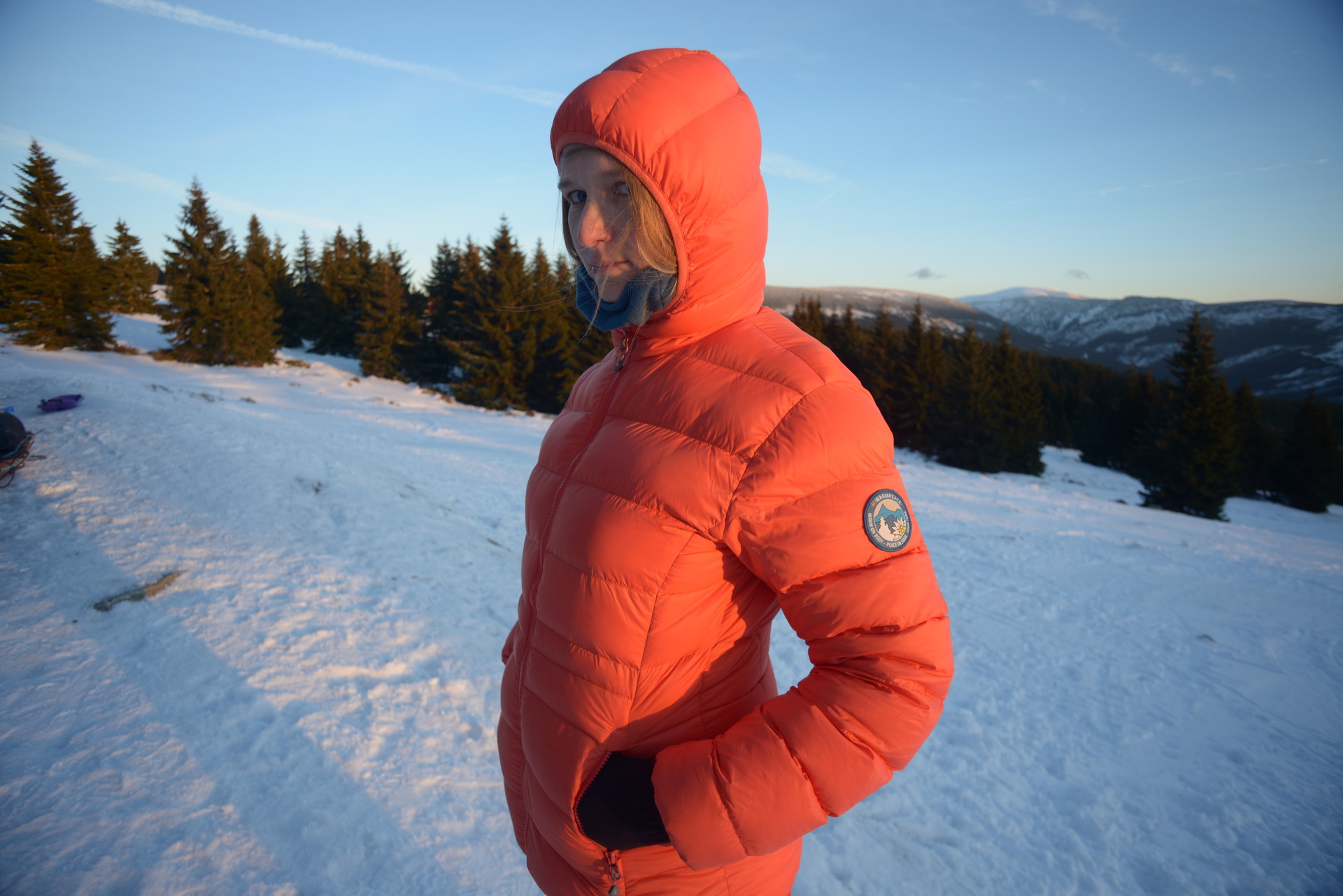 Péřová bunda Tacoma s nasazenou kapucí.