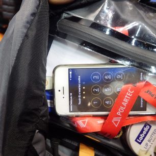 Lezecký batoh Eghen 22 a jeho vnitřní průhledná kapsa umožňuje ovládat dotykový telefon.