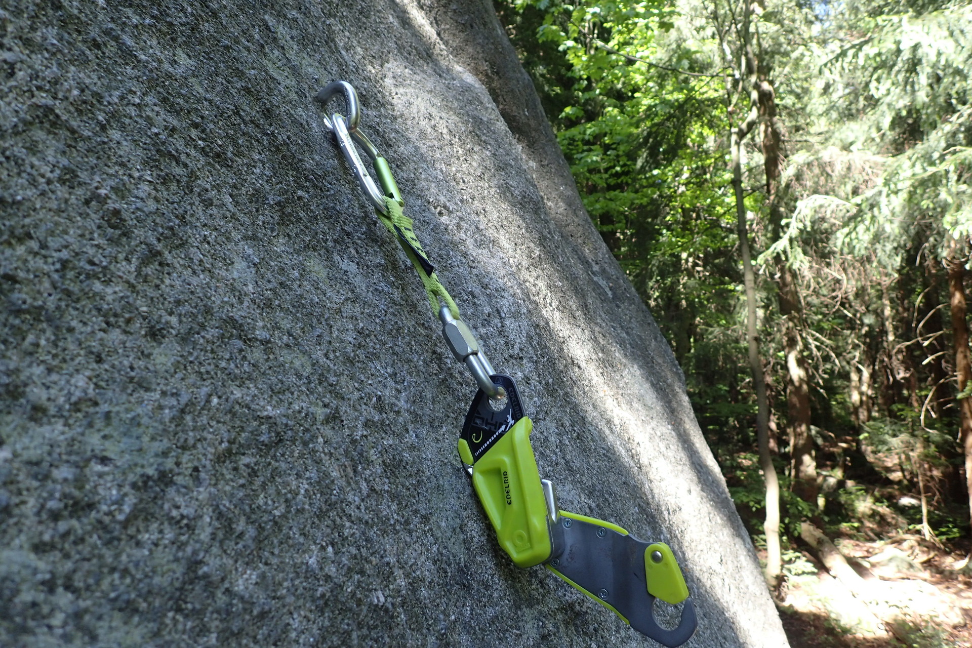 Zavěšený Edelrid OHM tak, aby lano prvolezce šlo od skály a ve směru šipek.
