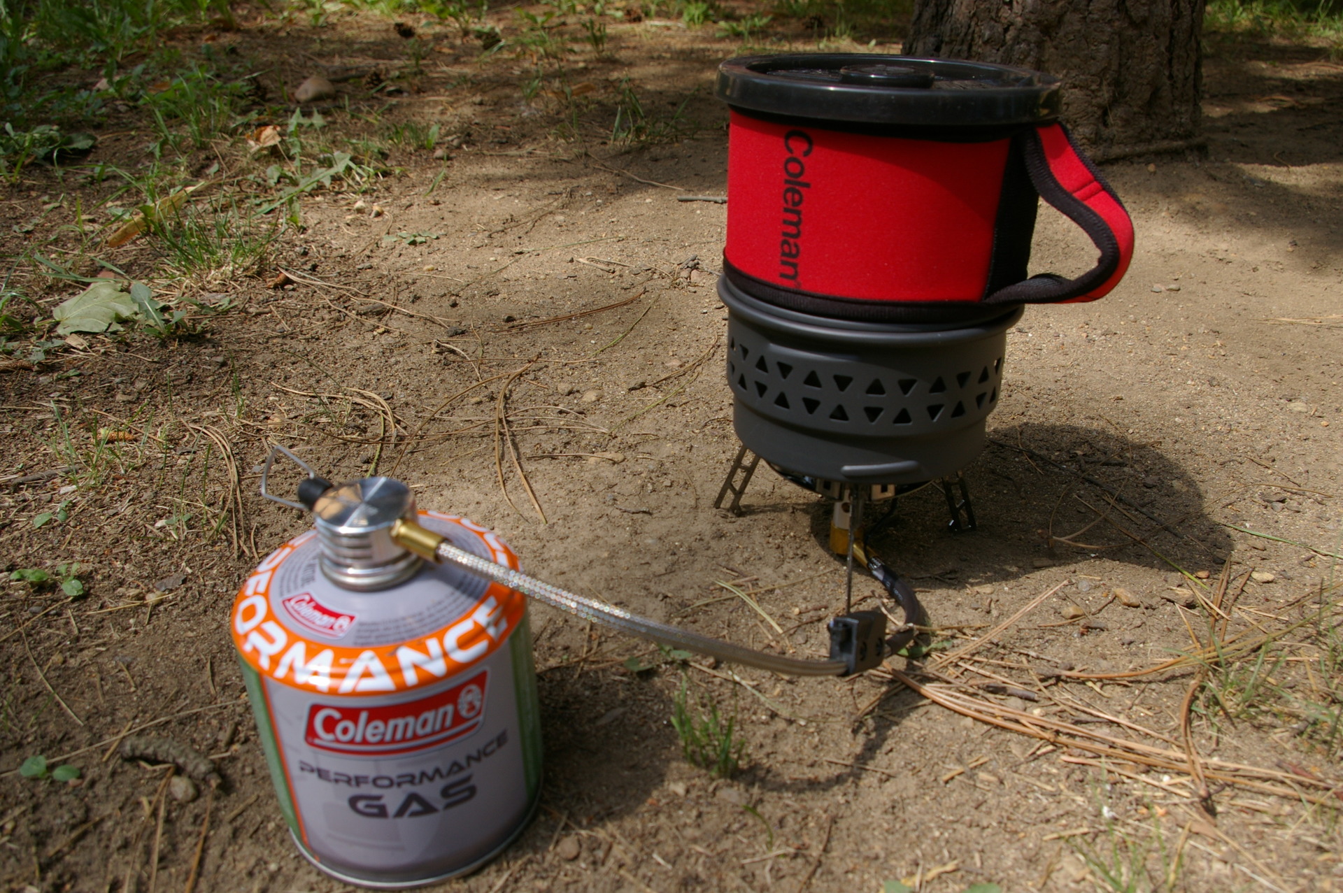 COLEMAN Fyrestorm Vařič s nasazeným hrncem při vaření tekutiny.