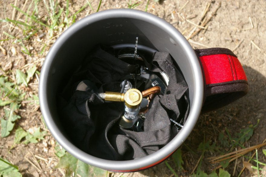 Vařič v hrnci v ochraném obalu.