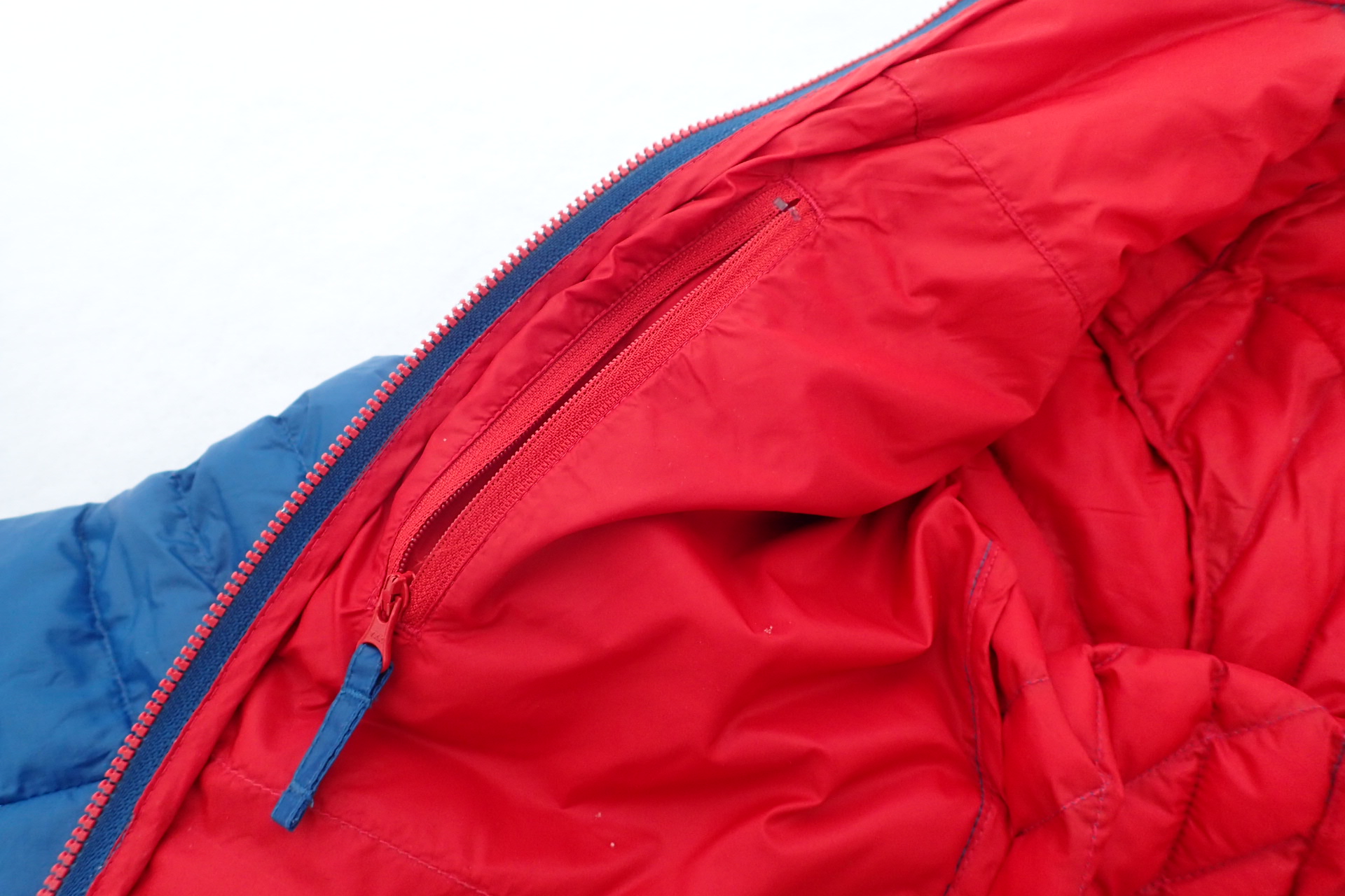 Pravá vnitřní kapsa s textilním táhlem tak, aby se minimalizovalo poškození spodního oblečení.