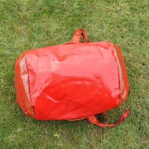 Tahání po mokré trávě tašce OSPREY Transporter neublížilo.