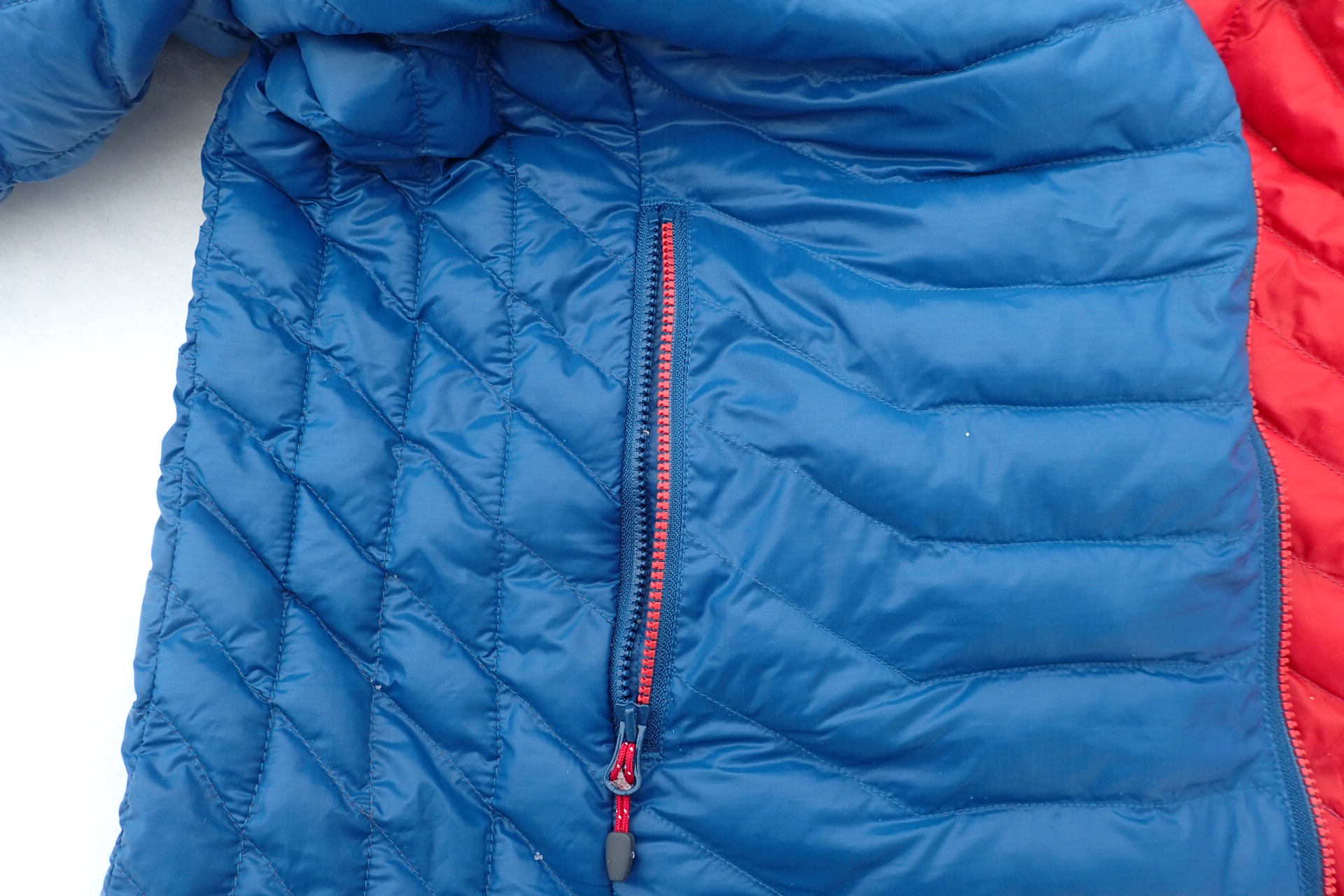 Vnější zip se šňůrkovým táhlem je kosticový a zajímavě řešený jako dvoubarevný.