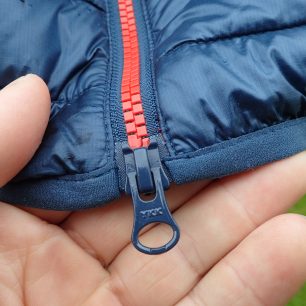 Dvojcestný zip YKK a detail pruženky na spodním okraji bundy Rafiki Colin II.