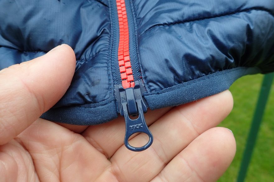 Dvojcestný zip YKK a detail pruženky na spodním okraji bundy Rafiki Colin II.