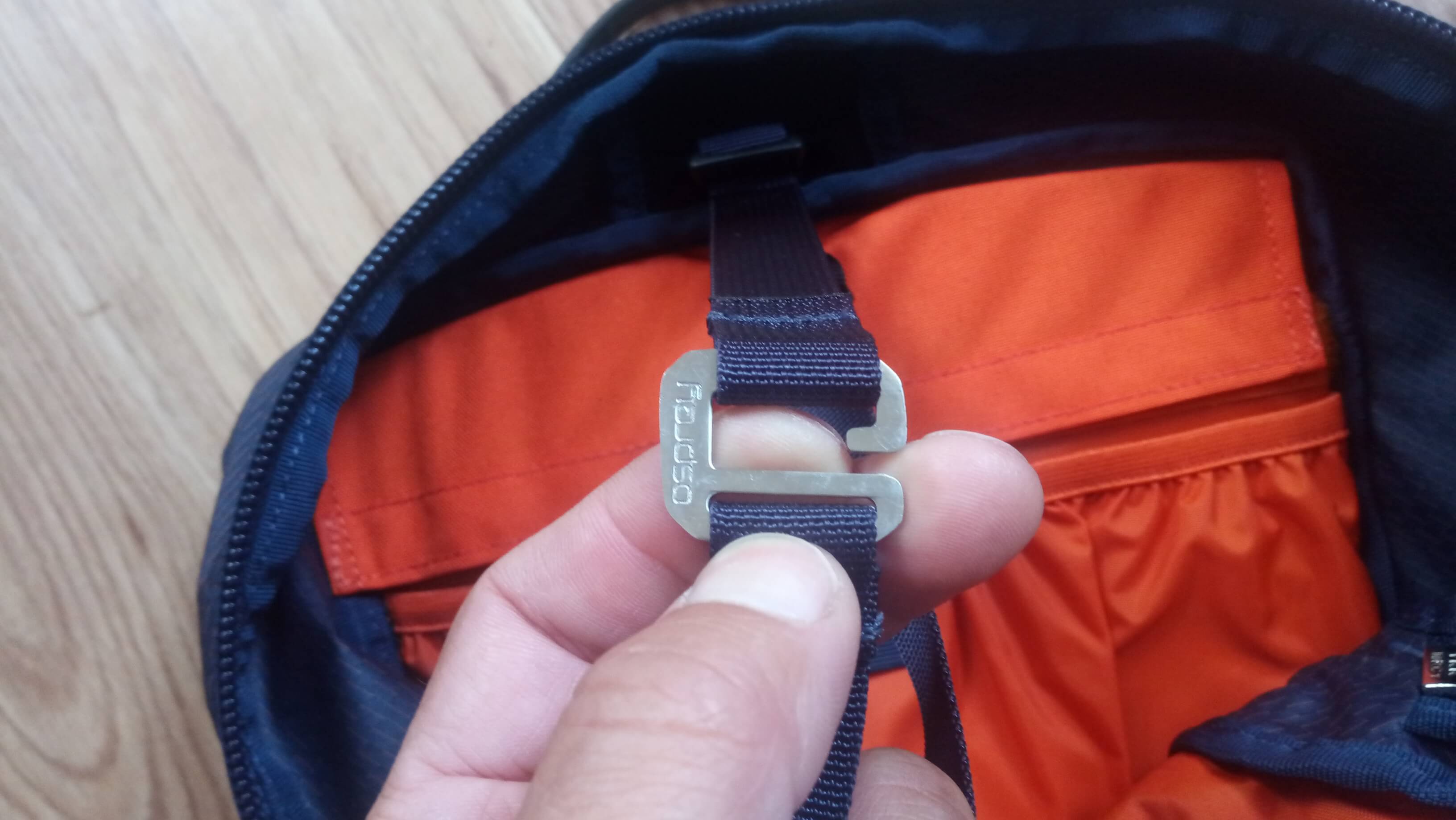 Kovový háček na vnitřním popruhu batohu OSPREY Mutant 22 pro stažení obsahu batohu nebo fixaci lana z vně.