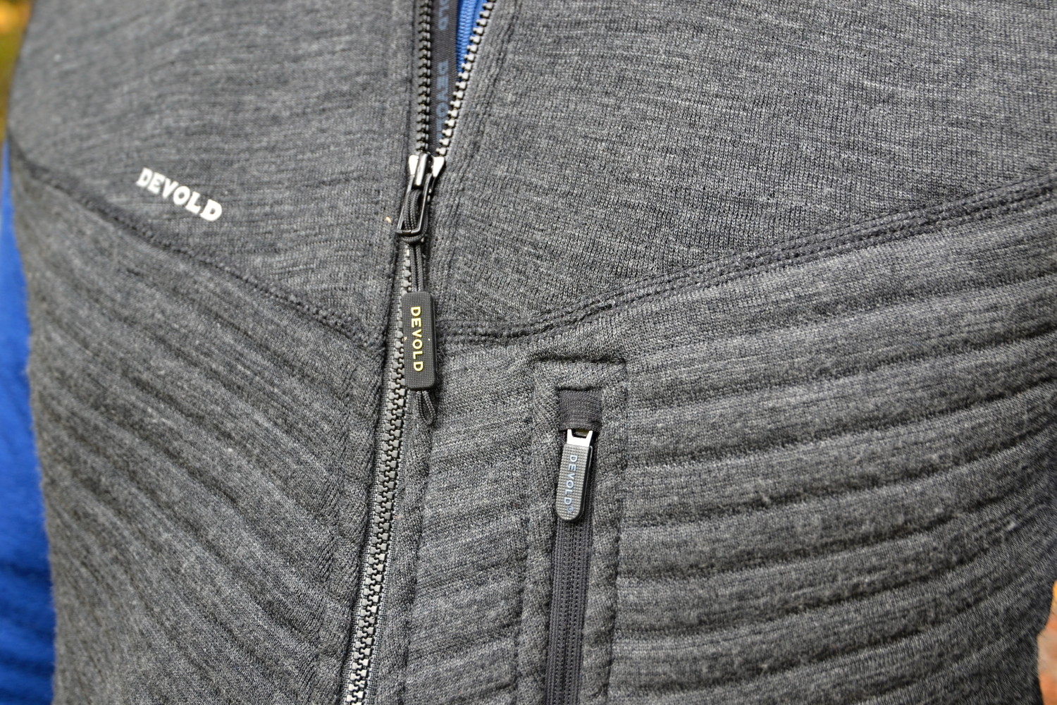 Detail zipu a náprsní kapsy vesty Devold Tinden Spacer.