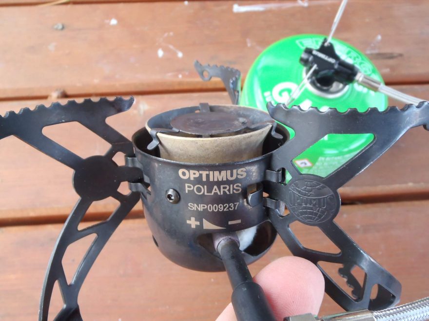 Detail vařiče OPTIMUS Polaris Optifuel se sklápěcí trojnožkou.