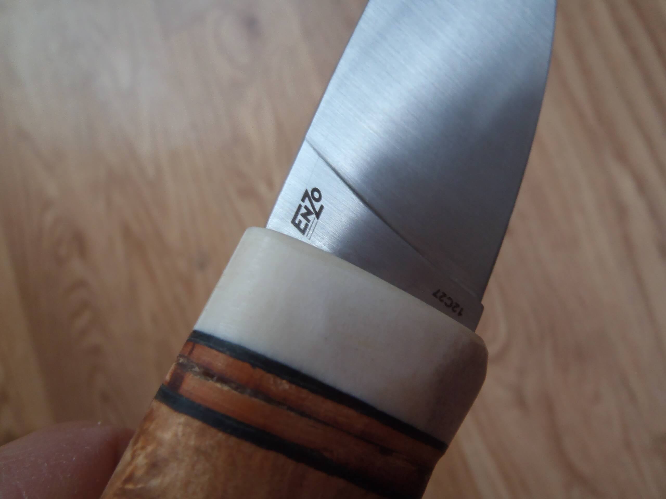 Detail na logo EnZo a ocel 12C27 na čepeli stavebnicového nože - EnZo Skinner Curly birch kit.