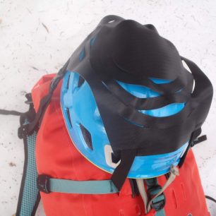 Fixace helmy na batoh Ortlieb Atrack pomocí nylonové síťky se čtyřmi popruhy.